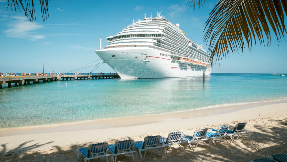Luxury cruise ship docked in the Caribbean. Secure your cruise with Overland Park travel agent expert Mary Beth Lynn.